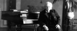 Edvard Grieg sitting at the piano